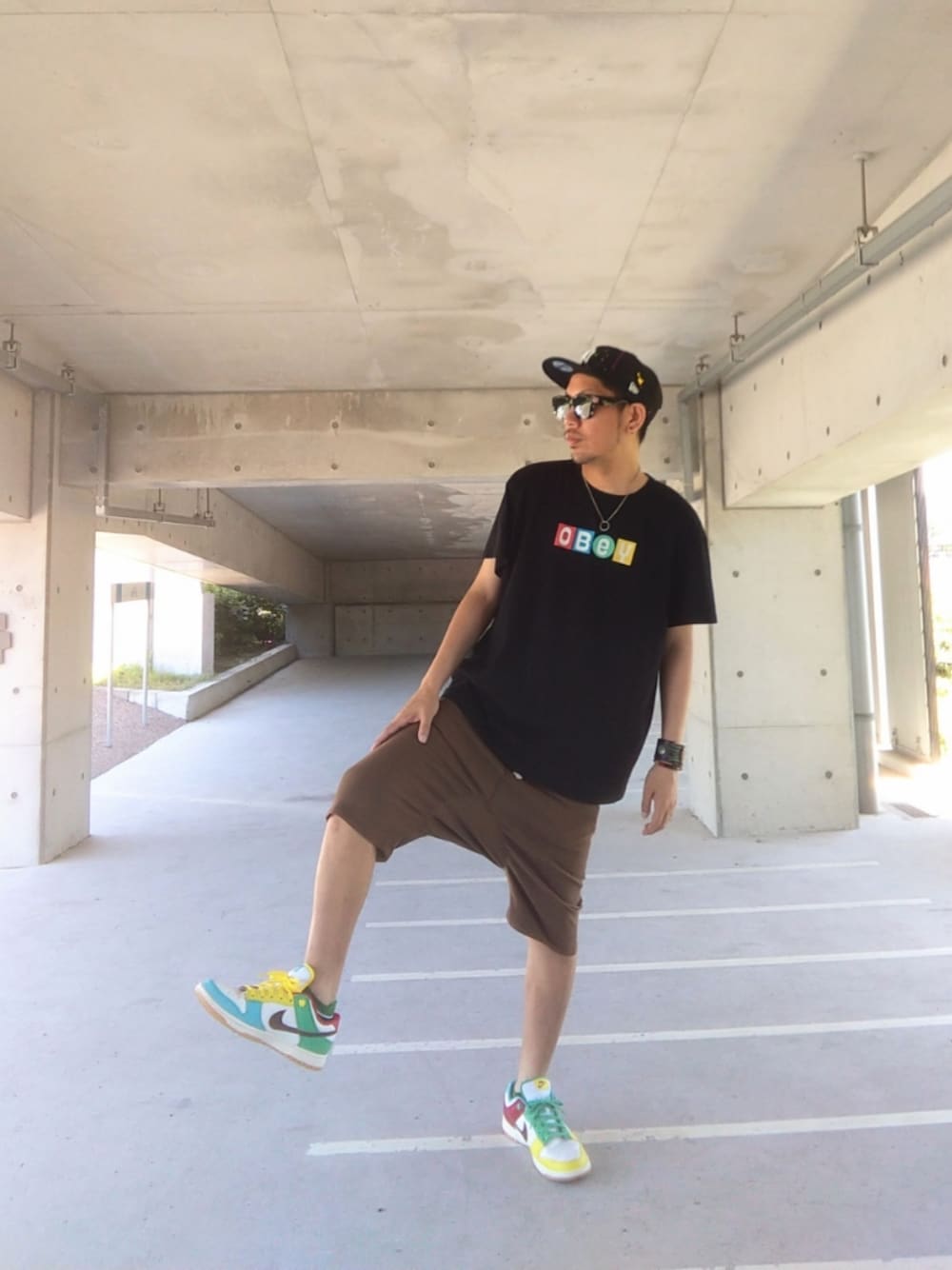 ブラック系のTシャツ/カットソー、ブラウン系のその他パンツ、その他のスニーカーを着用したメンズの夏コーディネートの1枚目の写真