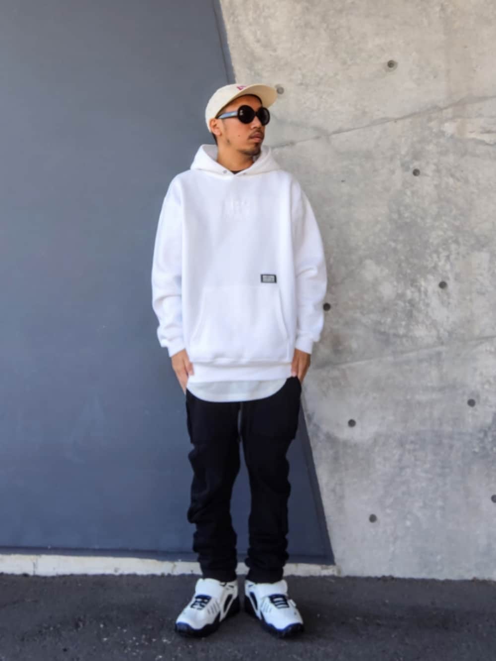 ホワイト系のパーカー、ブラック系のその他パンツ、ホワイト系のスニーカーを着用したメンズの冬コーディネートの1枚目の写真