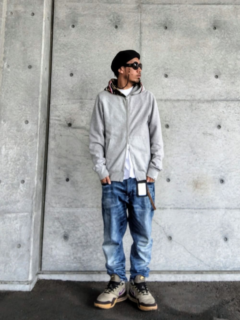 グレー系のパーカー、ホワイト系のTシャツ/カットソー、ブルー系のデニムパンツを着用したメンズの春コーディネートの1枚目の写真