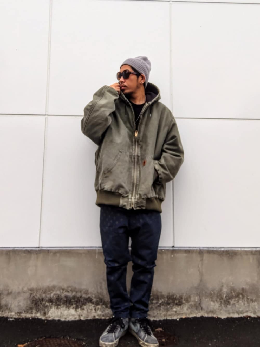 グリーン系のジャケット/アウター、ブルー系のその他パンツ、ブラック系のスニーカーを着用したメンズの冬コーディネートの1枚目の写真