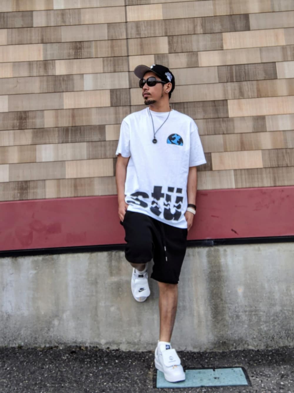 ホワイト系のTシャツ/カットソー、ブラック系のその他パンツ、ホワイト系のスニーカーを着用したメンズの夏コーディネートの1枚目の写真
