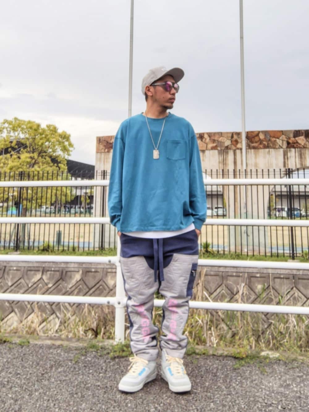 ブルー系のTシャツ/カットソー、ホワイト系のタンクトップ、ブルー系のカーゴパンツを着用したメンズの春コーディネートの1枚目の写真