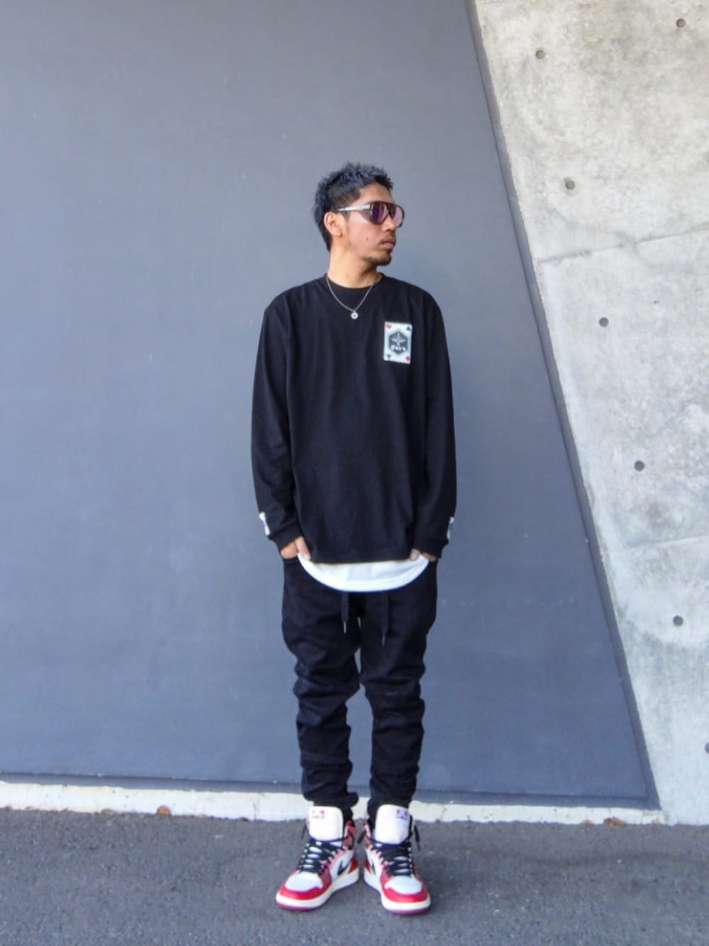 ブラック系のTシャツ/カットソー、ホワイト系のタンクトップ、ブラック系のデニムパンツを着用したメンズの春コーディネートの1枚目の写真