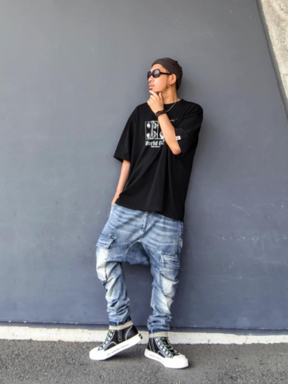ブラック系のTシャツ/カットソー、ブルー系のデニムパンツ、ブラック系のスニーカーを着用したメンズの夏コーディネートの1枚目の写真