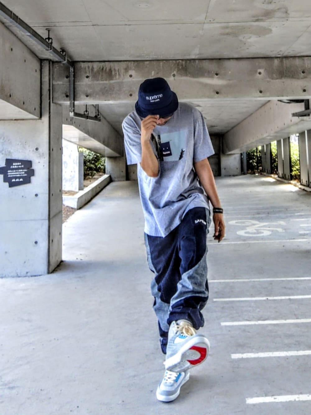 グレー系のTシャツ/カットソー、ブルー系のデニムパンツ、グレー系のスニーカーを着用したメンズの夏コーディネートの1枚目の写真