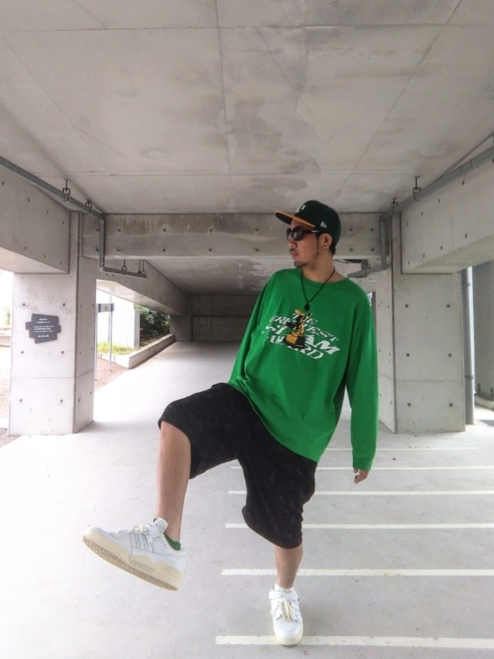グリーン系のTシャツ/カットソー、ブラック系のパンツ、ホワイト系のスニーカーを着用したメンズの夏コーディネートの1枚目の写真