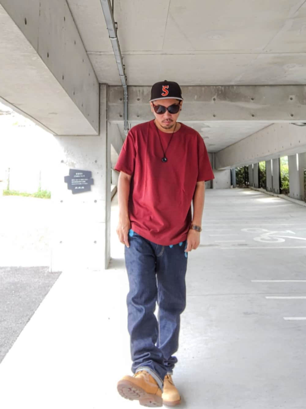 ブラウン系のTシャツ/カットソー、ブルー系のデニムパンツ、イエロー系のブーツを着用したメンズの秋コーディネートの1枚目の写真