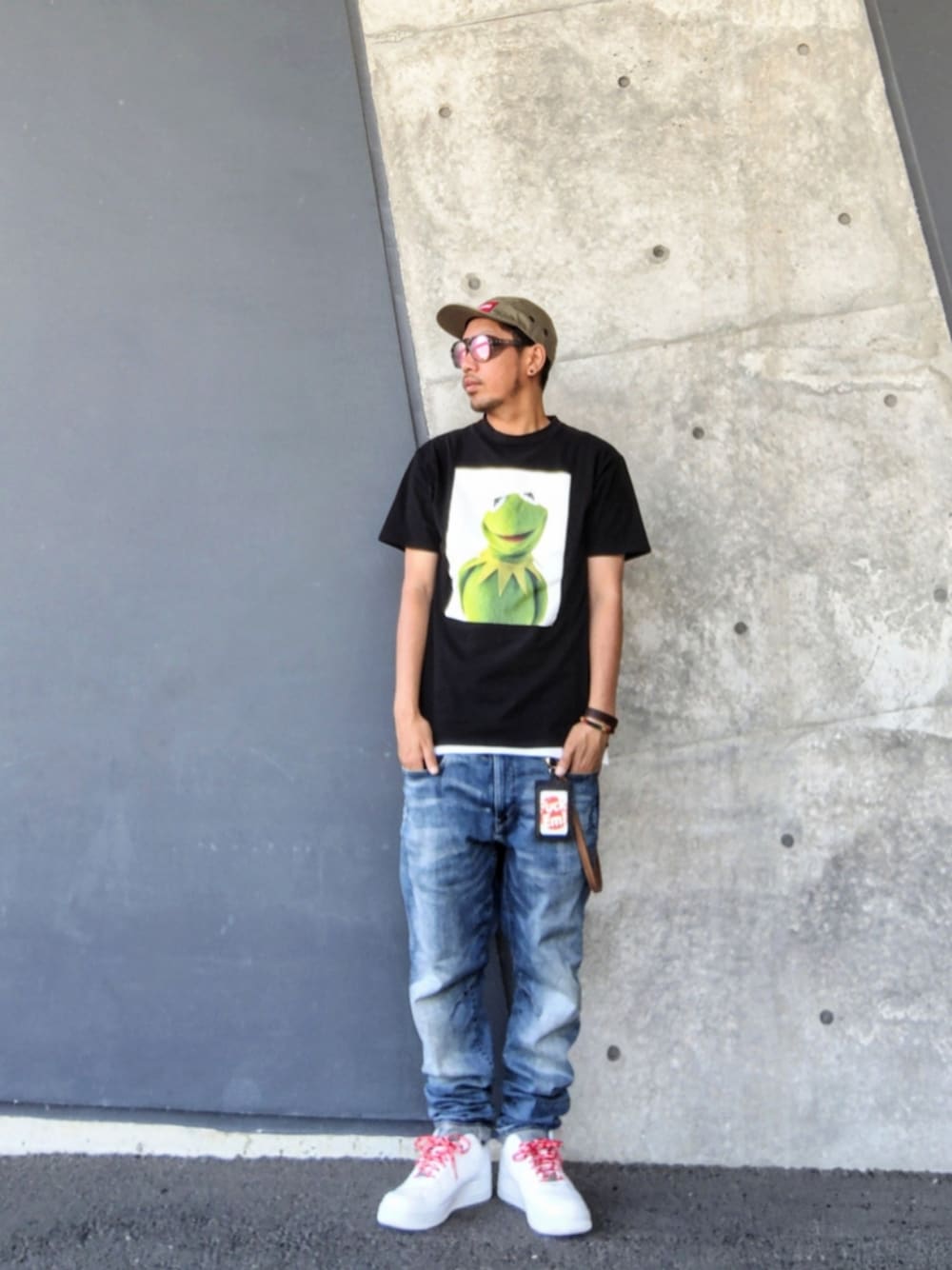ブラック系のTシャツ/カットソー、ブルー系のデニムパンツ、ホワイト系のスニーカーを着用したメンズの夏コーディネートの1枚目の写真
