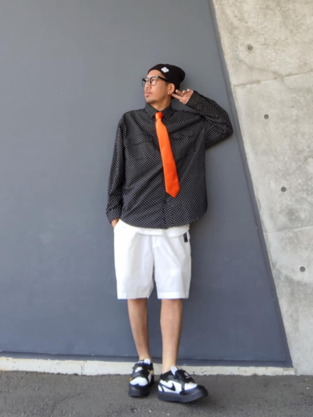 オレンジ系のネクタイ、ブラック系のシャツ/ブラウス、ホワイト系のその他パンツを着用したメンズの春コーディネートの1枚目の写真