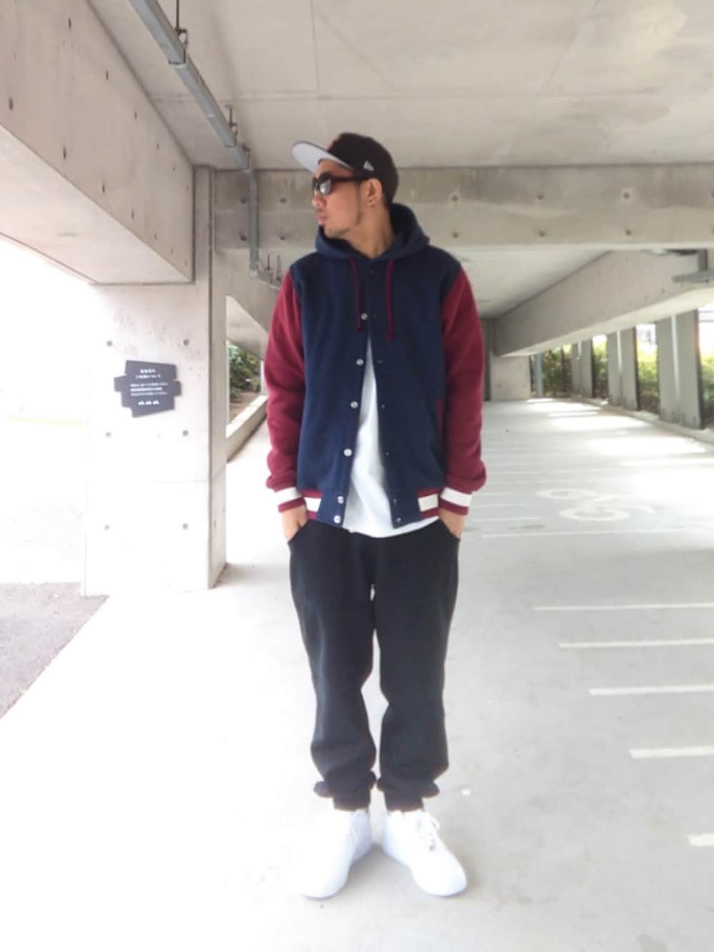 ブルー系のスタジャン、ホワイト系のTシャツ/カットソー、ブラック系のスウェットパンツを着用したメンズの春コーディネートの1枚目の写真