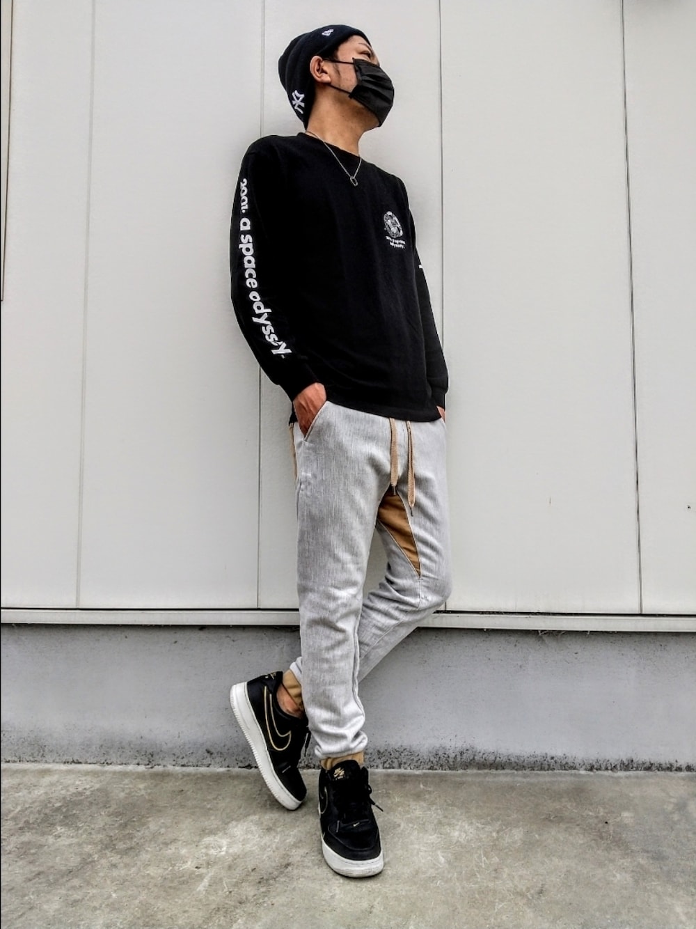 ブラック系のTシャツ/カットソー、ブラック系のスニーカー、グレー系のスウェットパンツを着用したメンズの夏コーディネートの1枚目の写真