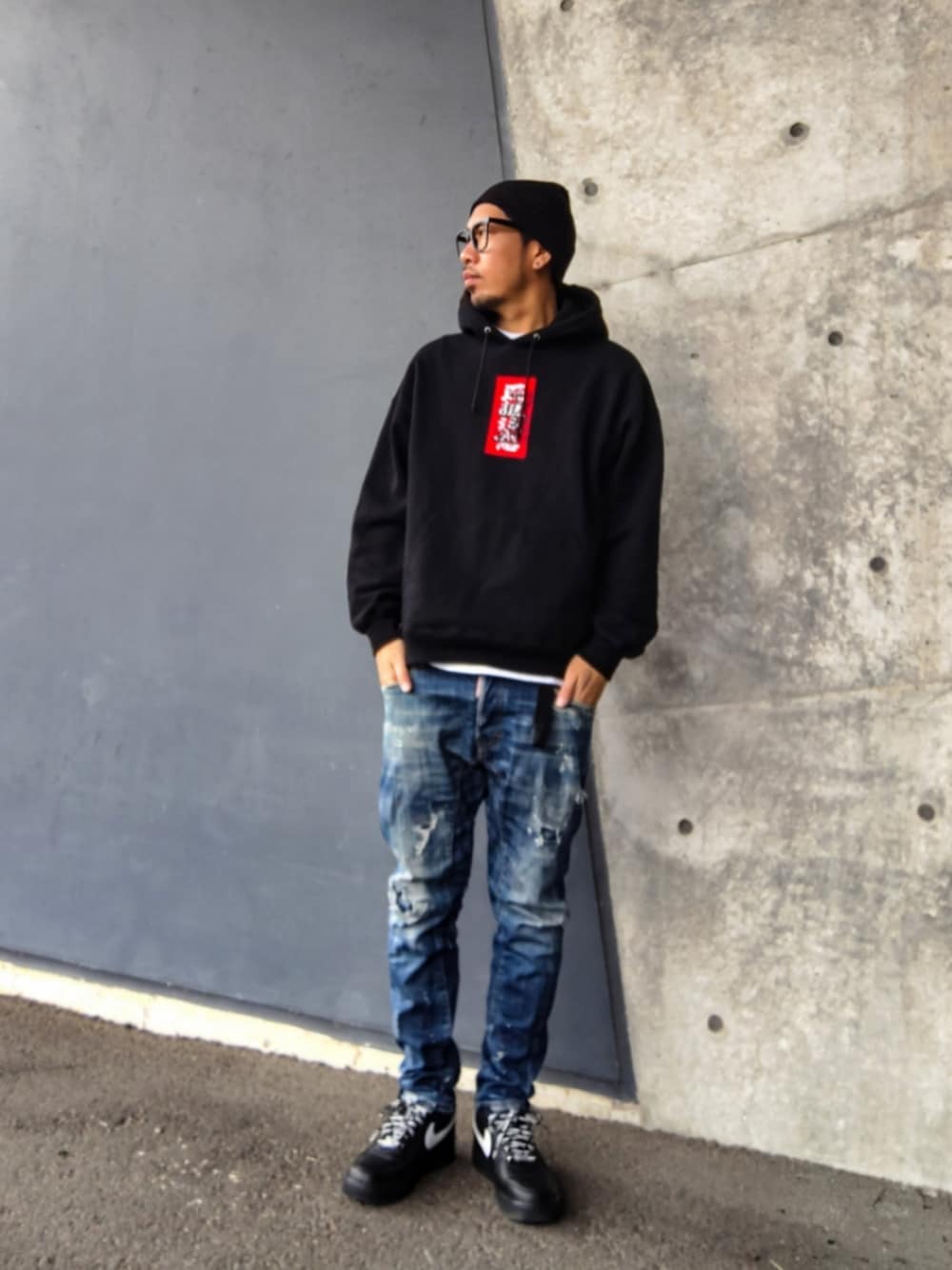 ブラック系のパーカー、ブルー系のデニムパンツ、ブラック系のスニーカーを着用したメンズの冬コーディネートの1枚目の写真