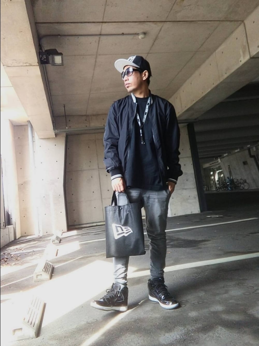 ブラック系のTシャツ/カットソー、その他のブルゾン、ブラック系のバッグを着用したメンズの春コーディネートの1枚目の写真