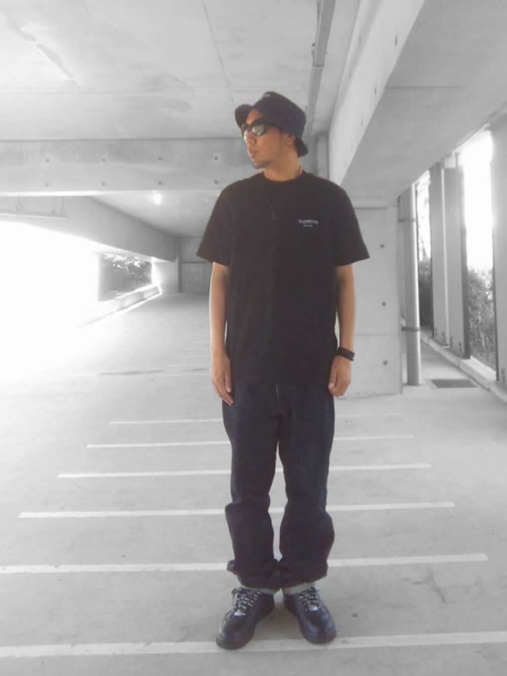 ブラック系のTシャツ/カットソー、ブルー系のデニムパンツ、ブラック系のスニーカーを着用したメンズの夏コーディネートの1枚目の写真
