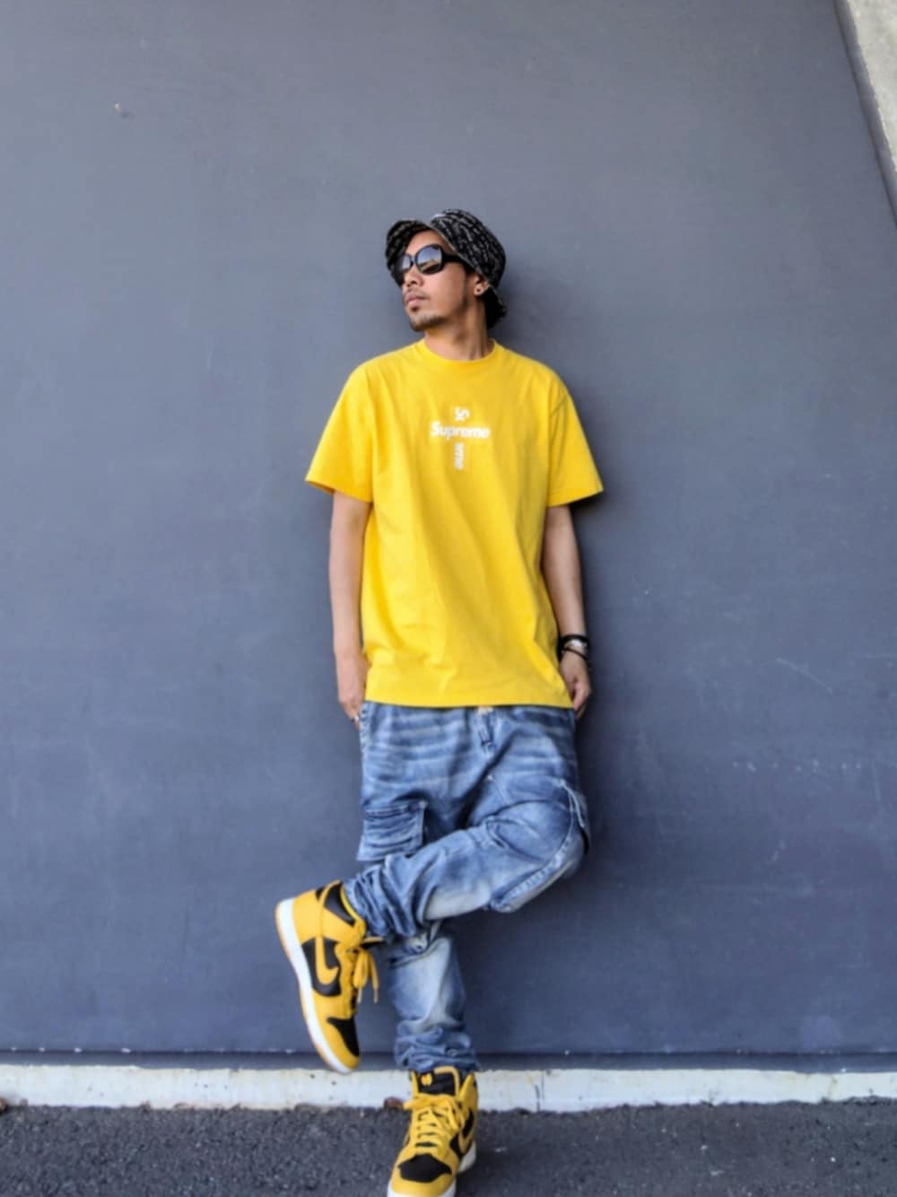 イエロー系のTシャツ/カットソー、ブルー系のデニムパンツ、イエロー系のスニーカーを着用したメンズの春コーディネートの1枚目の写真