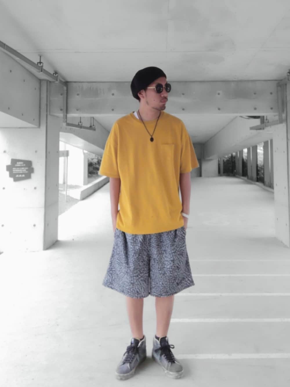 イエロー系のTシャツ/カットソー、グレー系のパンツ、ブラック系のスニーカーを着用したメンズの夏コーディネートの1枚目の写真