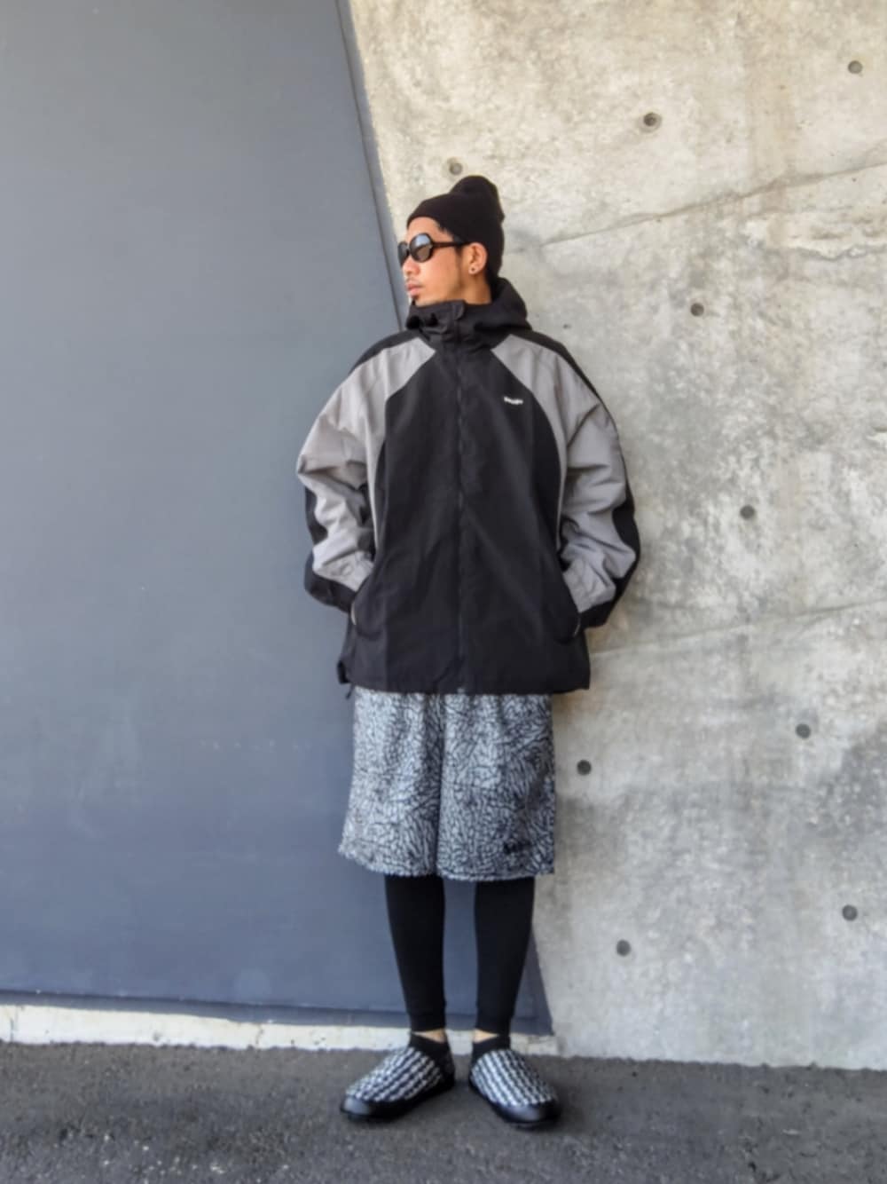 ブラック系のブルゾン、グレー系のパンツ、ブラック系のその他シューズを着用したメンズの春コーディネートの1枚目の写真