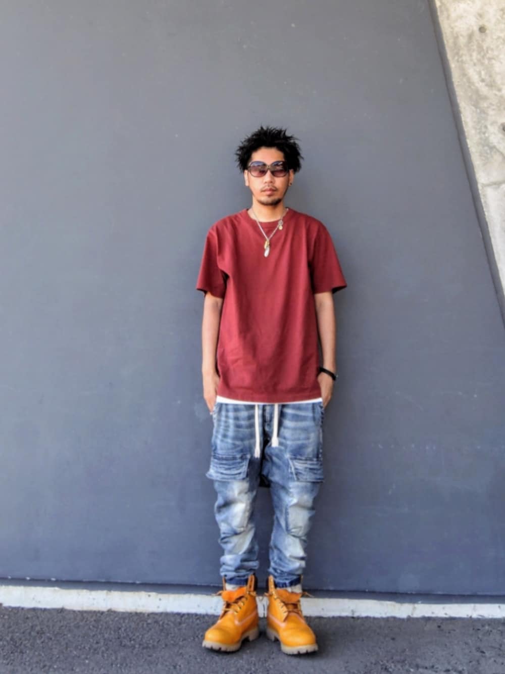 ブラウン系のTシャツ/カットソー、ホワイト系のタンクトップ、ブルー系のデニムパンツを着用したメンズの夏コーディネートの1枚目の写真