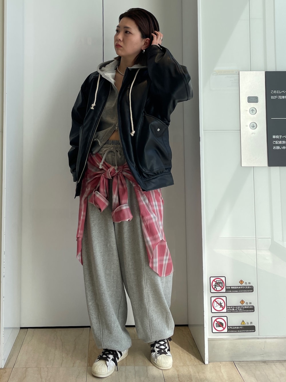 ブラック系のブルゾン、グレー系のパーカー、レッド系のシャツ/ブラウスを着用したレディースの冬コーディネートの1枚目の写真