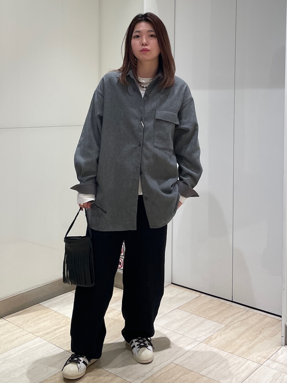 グレー系のシャツ/ブラウス、ブラック系のその他パンツ、ホワイト系のTシャツ/カットソーを着用したレディースの秋コーディネートの1枚目の写真
