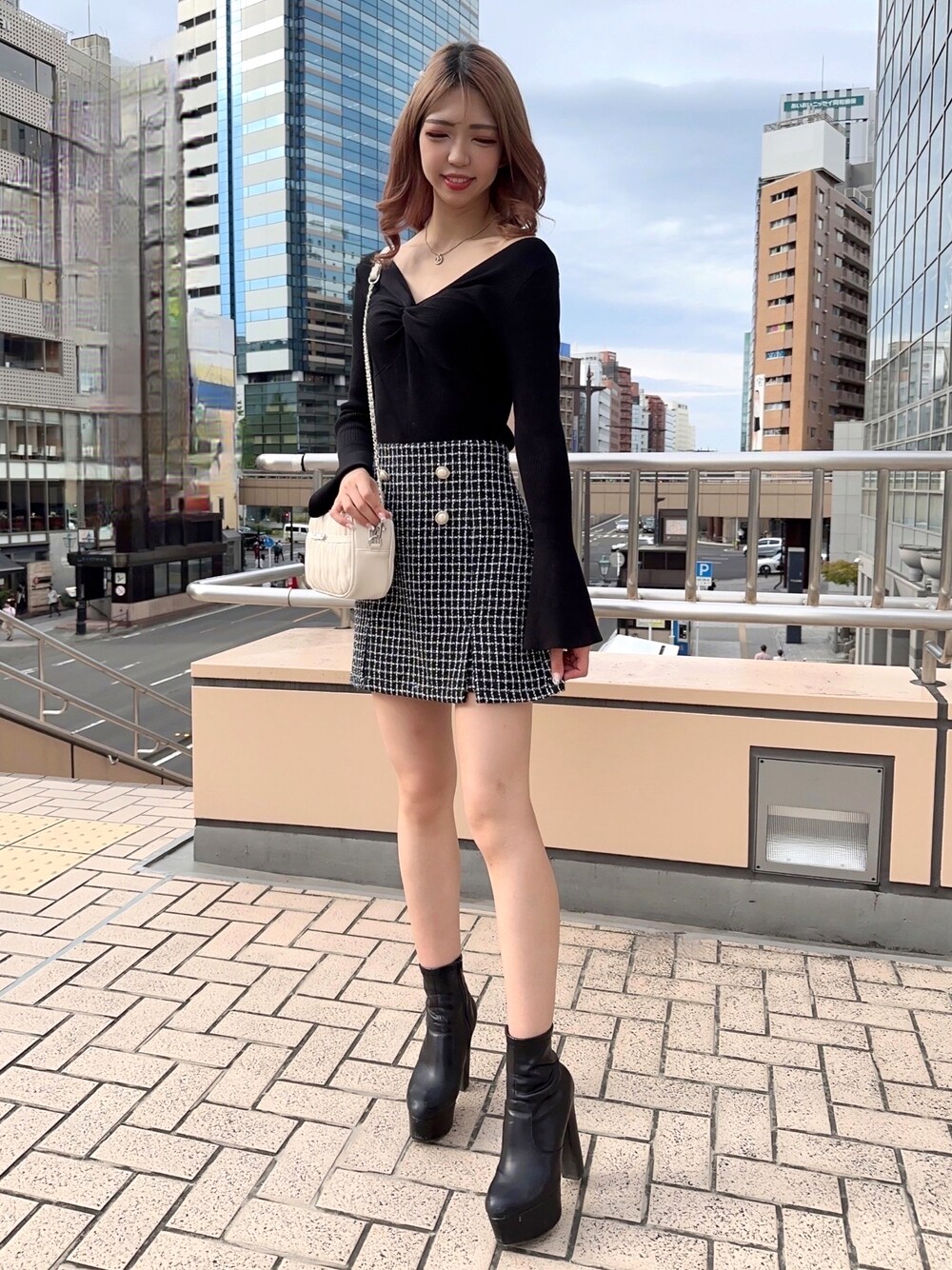 ブラック系のニット/セーター、ブラック系のその他パンツ、ホワイト系のハンドバッグを着用したレディースの秋コーディネートの1枚目の写真