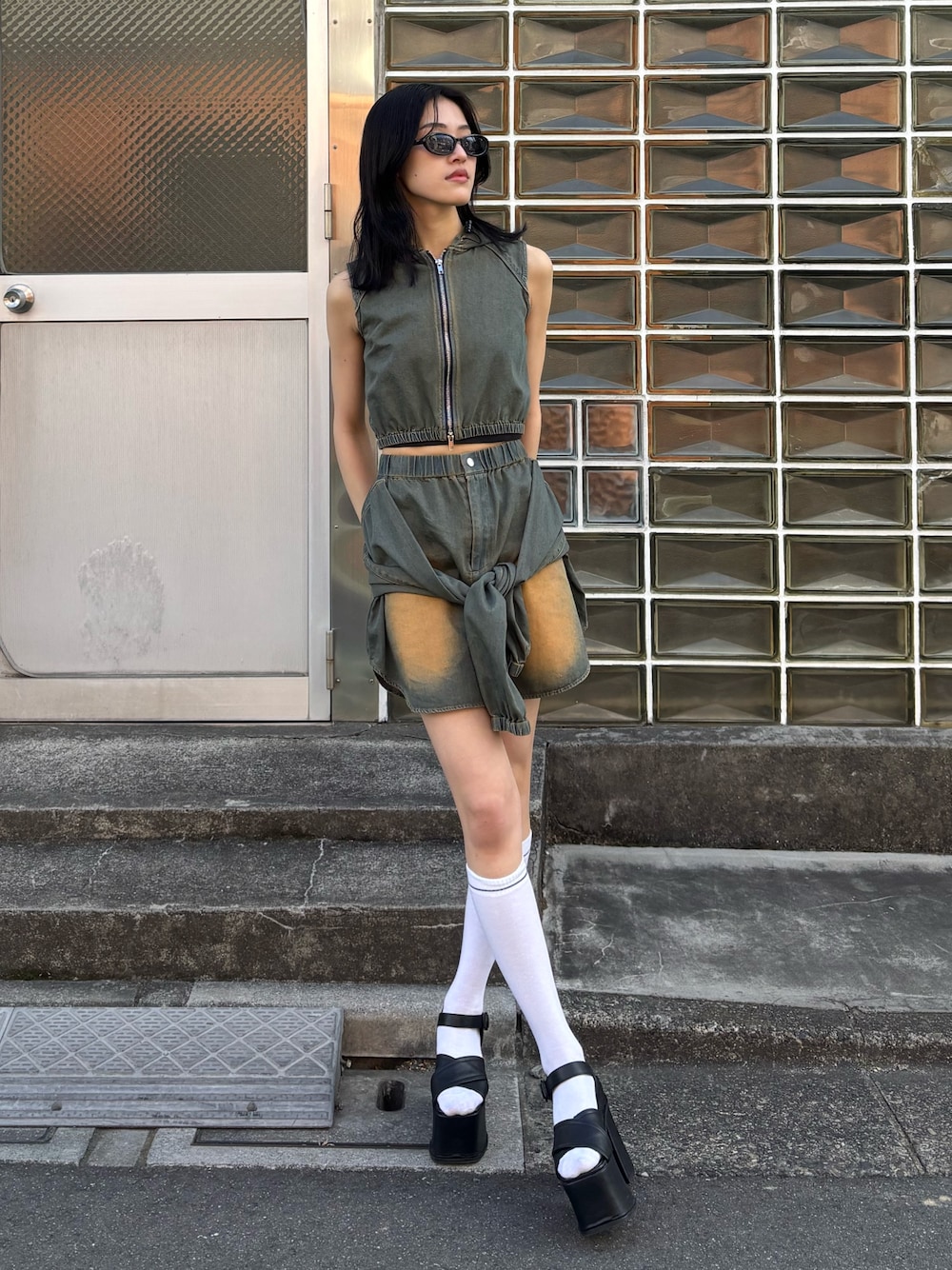 ブルー系のスカート、ブルー系のタンクトップ、ブラック系のサンダルを着用したレディースの春コーディネートの1枚目の写真