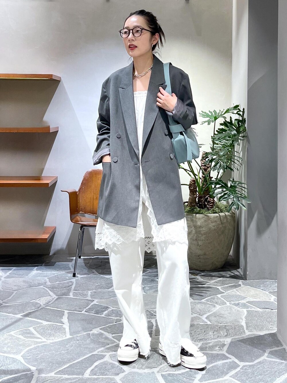 ブルー系のショルダーバッグ、ホワイト系のデニムパンツ、ホワイト系のスカートを着用したレディースの冬コーディネートの1枚目の写真