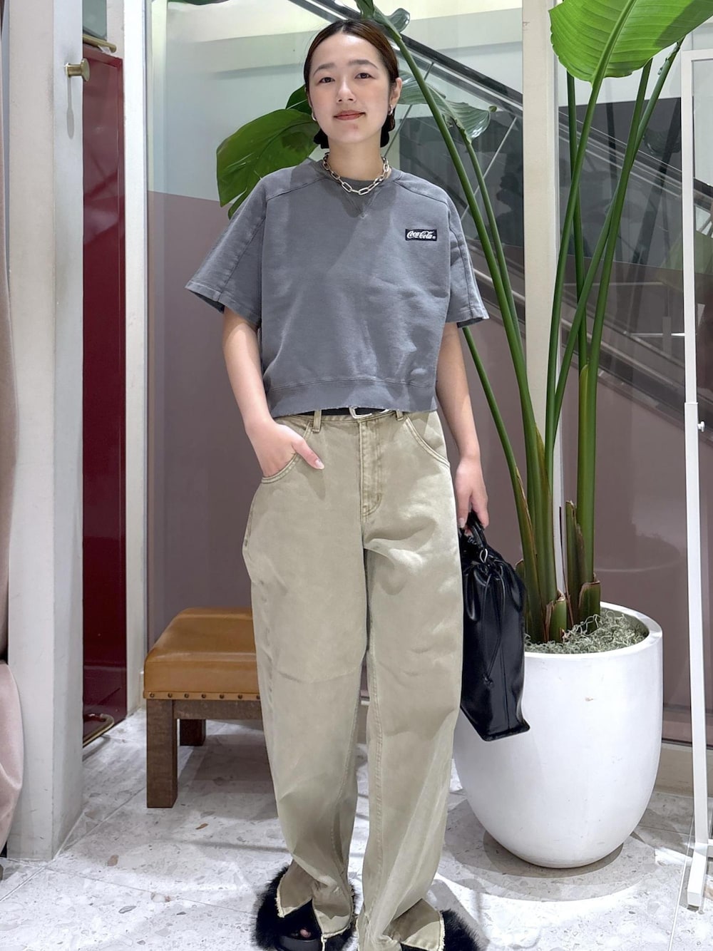ベージュ系のデニムパンツ、ブラック系のサンダル、ブラック系のショルダーバッグを着用したレディースの夏コーディネートの1枚目の写真