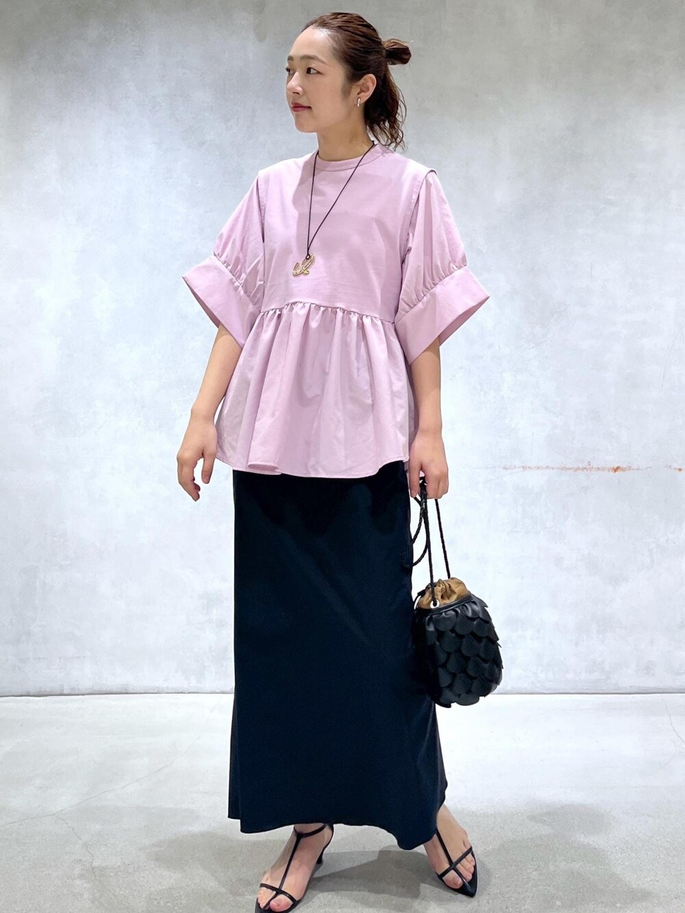 ブラック系のサンダル、ブラック系のスカート、ピンク系のTシャツ/カットソーを着用したレディースの春コーディネートの1枚目の写真