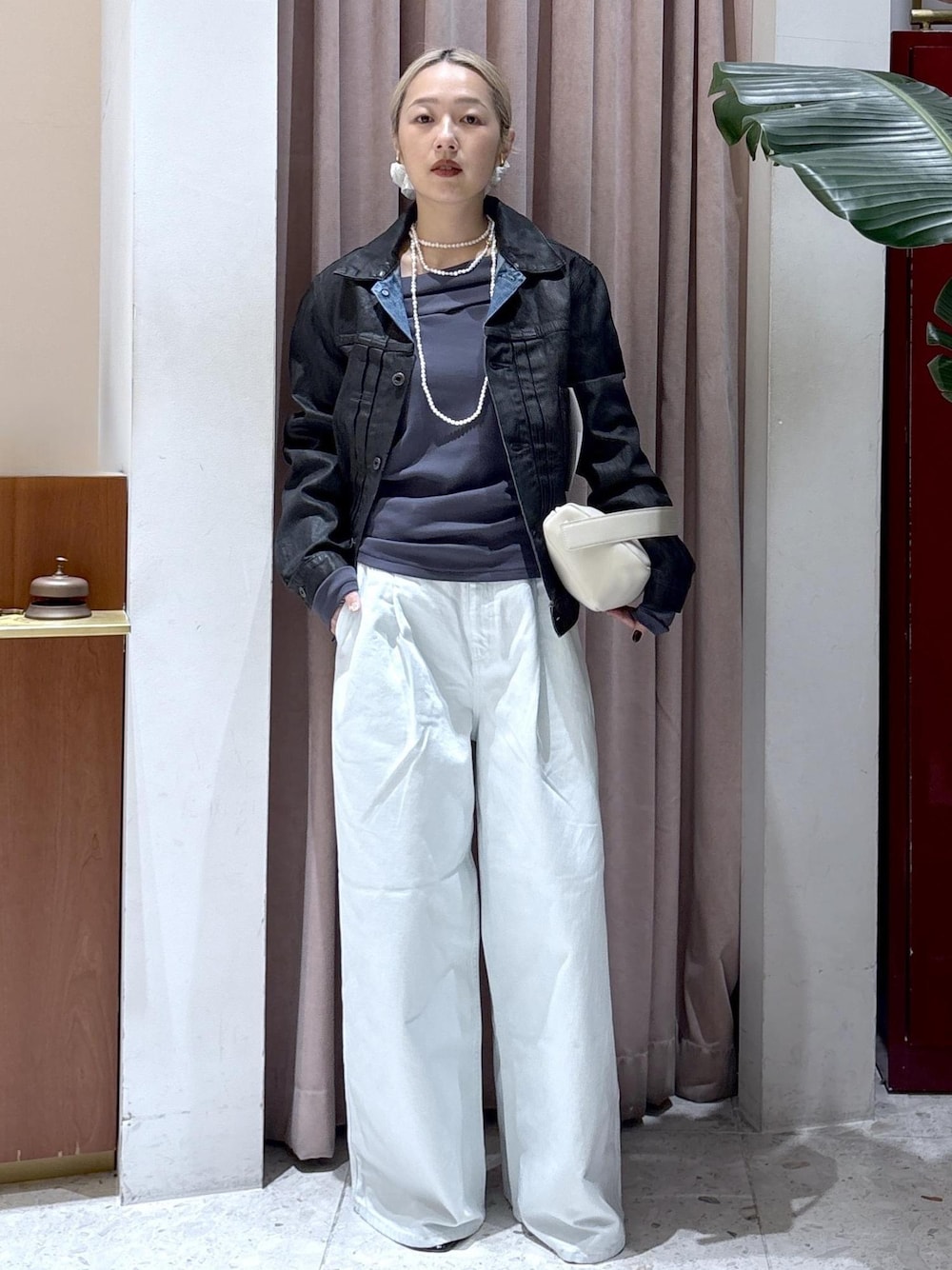 ホワイト系のハンドバッグ、グレー系のTシャツ/カットソー、ブルー系のデニムパンツを着用したレディースの冬コーディネートの1枚目の写真