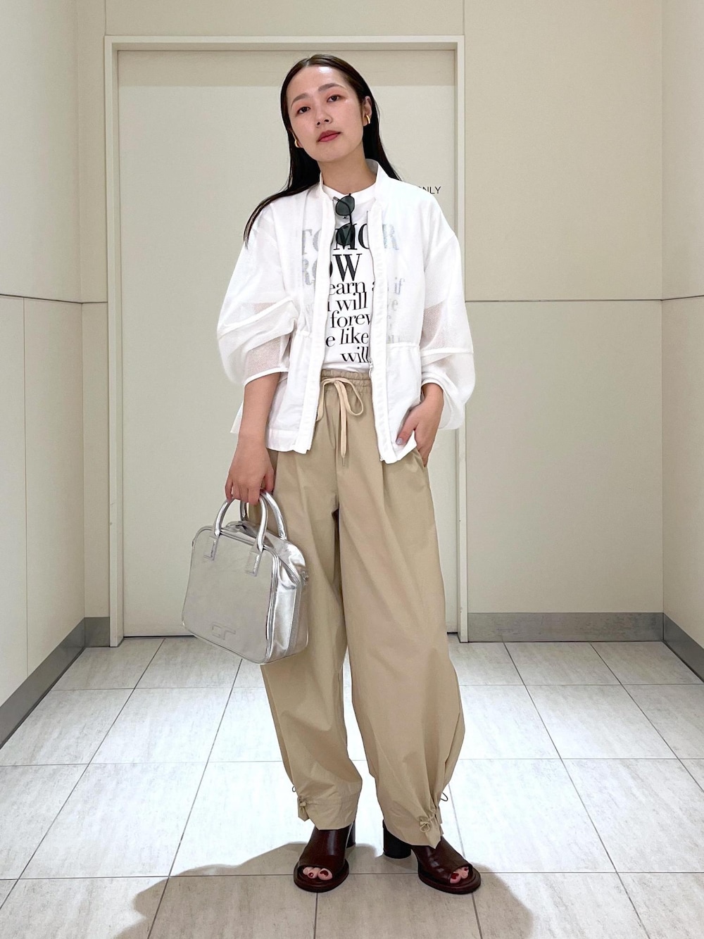 ホワイト系のTシャツ/カットソー、ブラウン系のサンダル、ホワイト系のカーディガン/ボレロを着用したレディースの春コーディネートの1枚目の写真