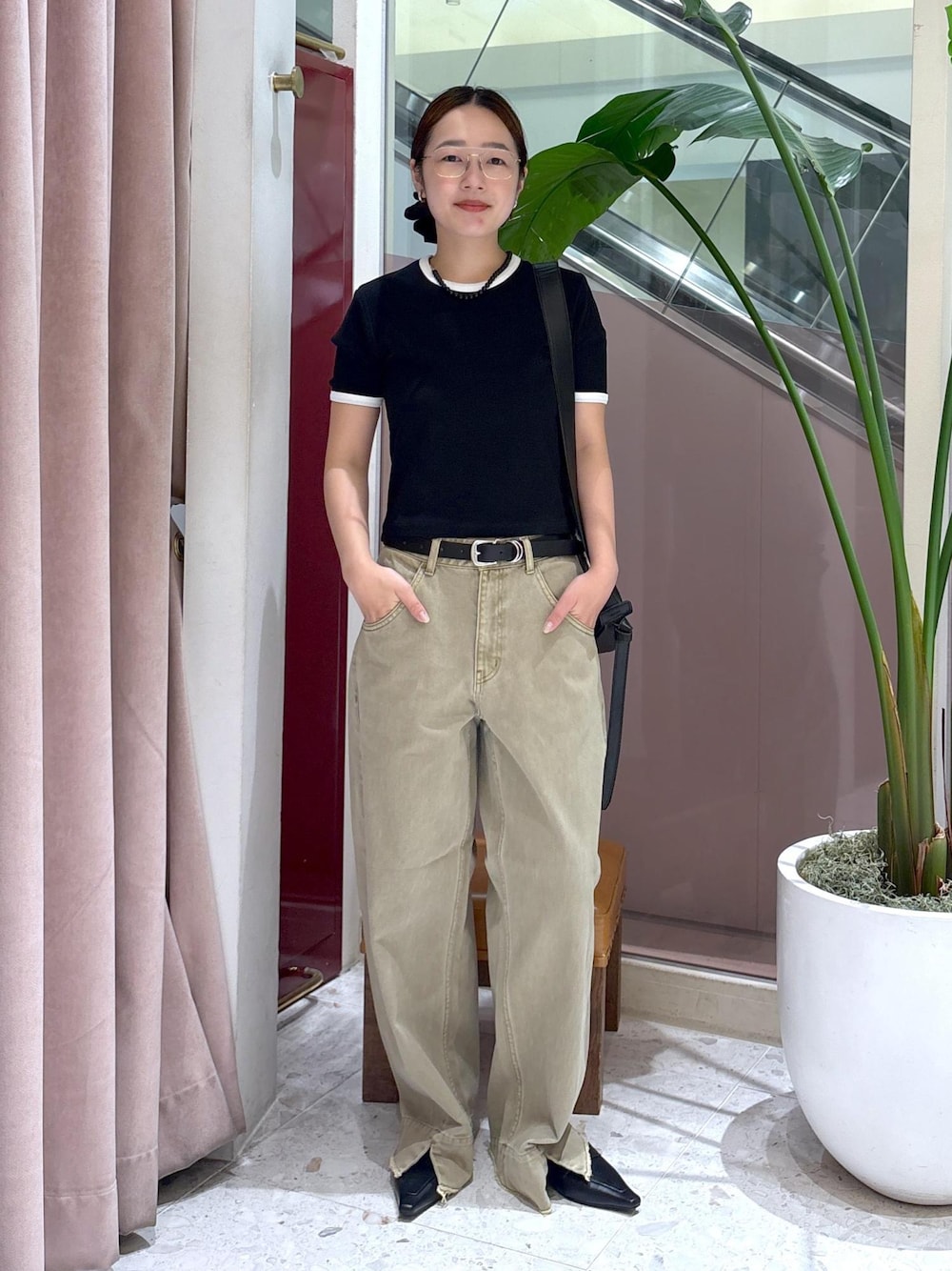 ブラック系のショルダーバッグ、ベージュ系のデニムパンツ、ブラック系のサンダルを着用したレディースの夏コーディネートの1枚目の写真