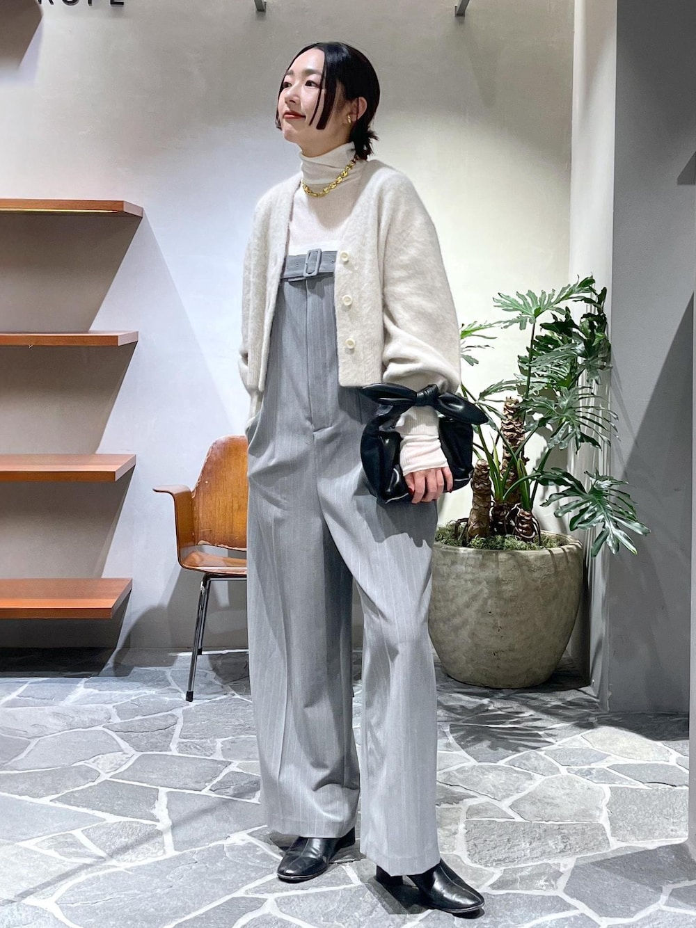 ホワイト系のカーディガン/ボレロ、ホワイト系のニット/セーター、ブラック系のショルダーバッグを着用したレディースの冬コーディネートの1枚目の写真