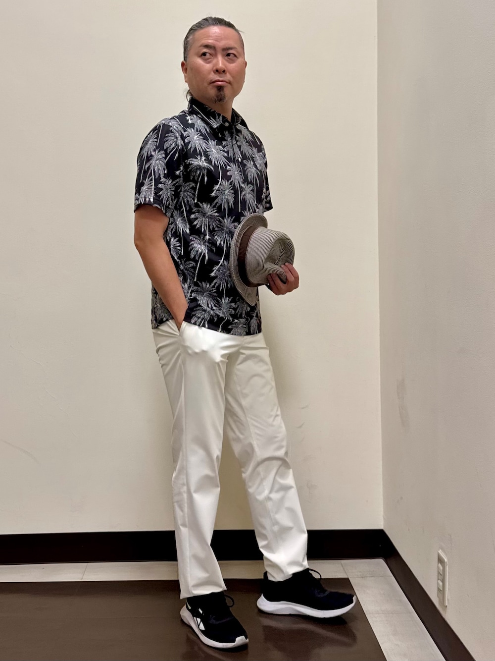 ブラック系のポロシャツ、ホワイト系のその他パンツを着用したメンズの夏コーディネートの1枚目の写真
