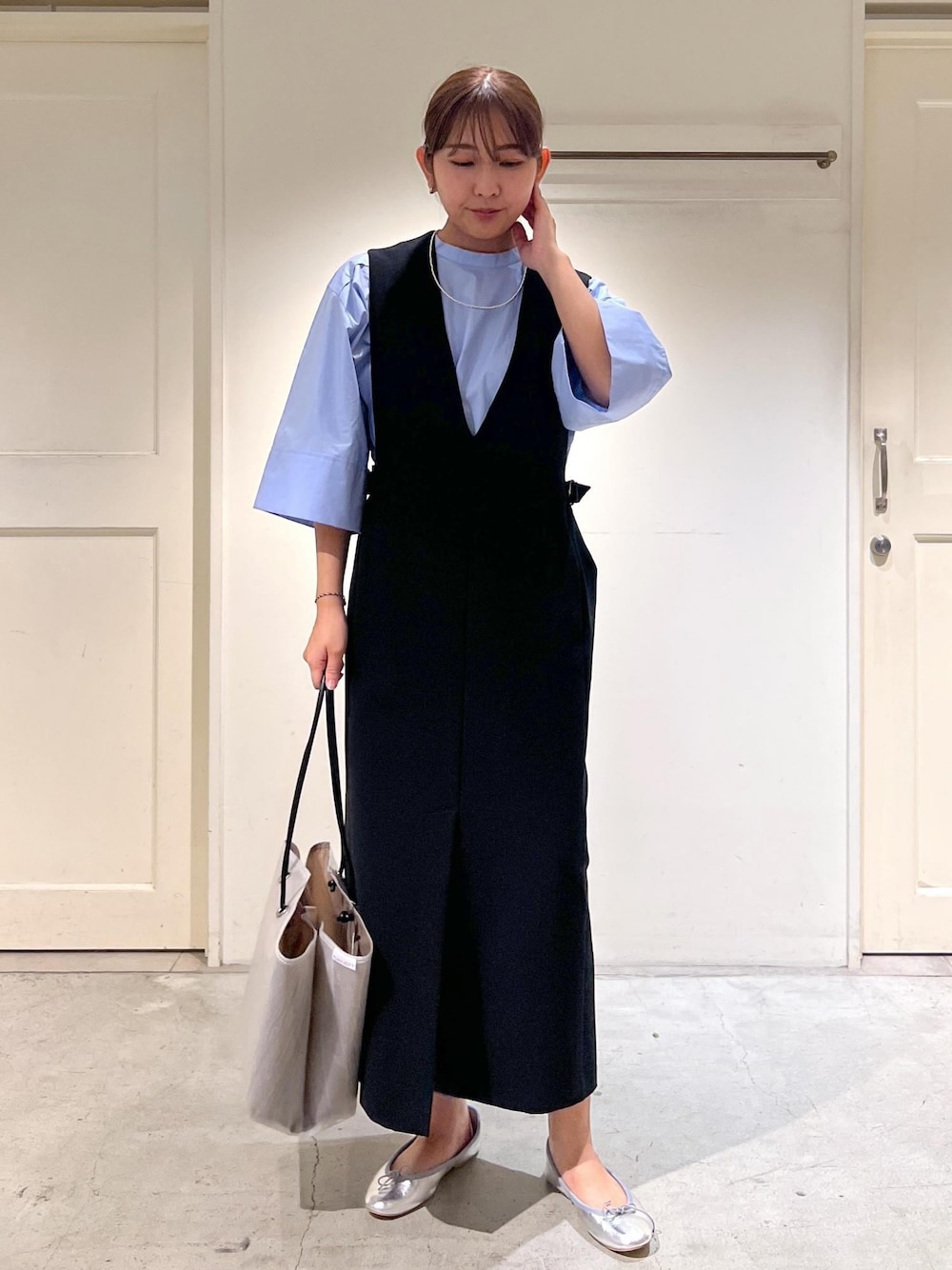シルバー系のバレエシューズ、ブルー系のシャツ/ブラウス、ブラック系のジャンパースカートを着用したレディースの夏コーディネートの1枚目の写真