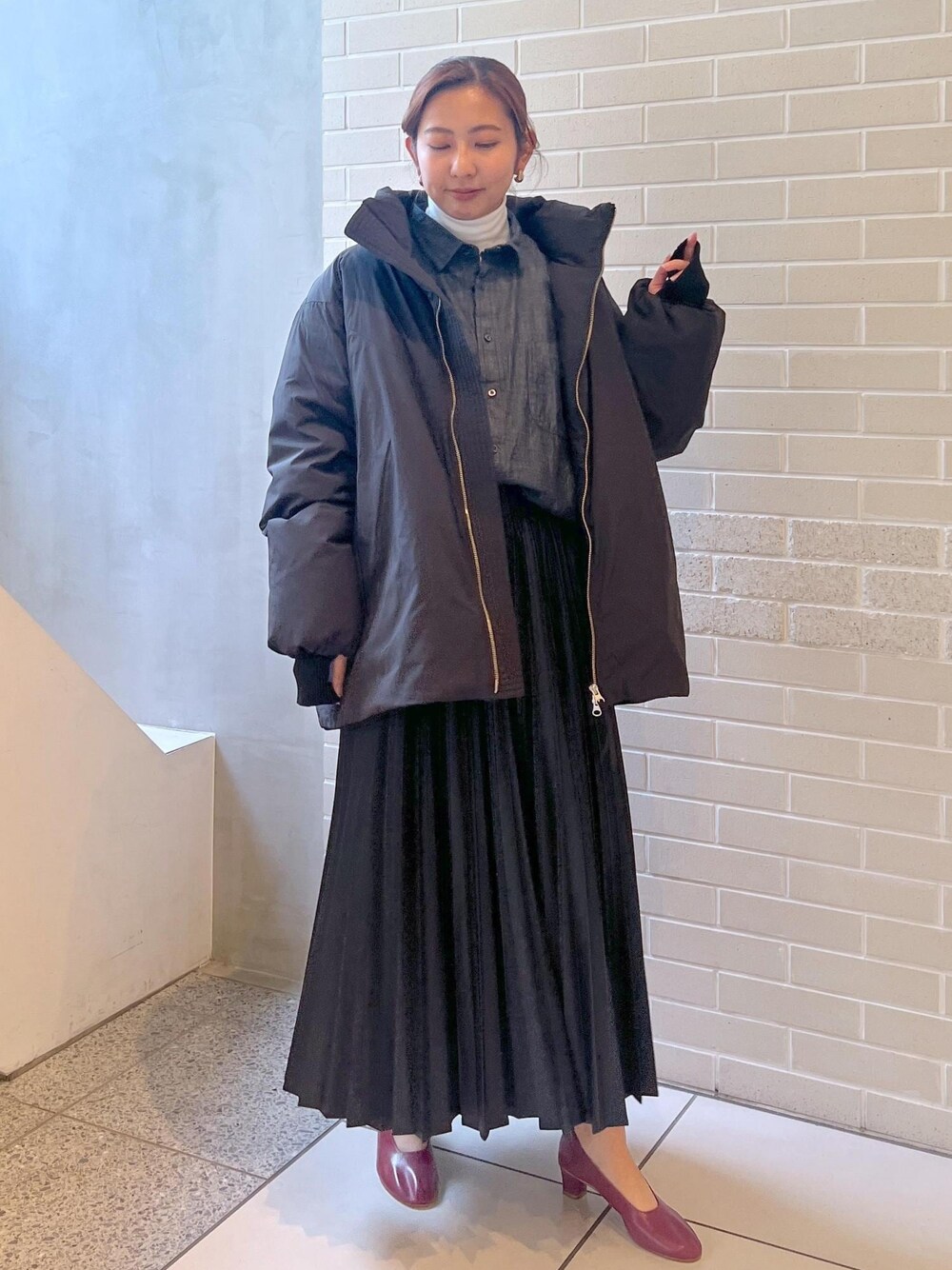 ブラック系のシャツ/ブラウス、ブラック系のダウンジャケット/コート、ホワイト系のTシャツ/カットソーを着用したレディースの秋コーディネートの1枚目の写真