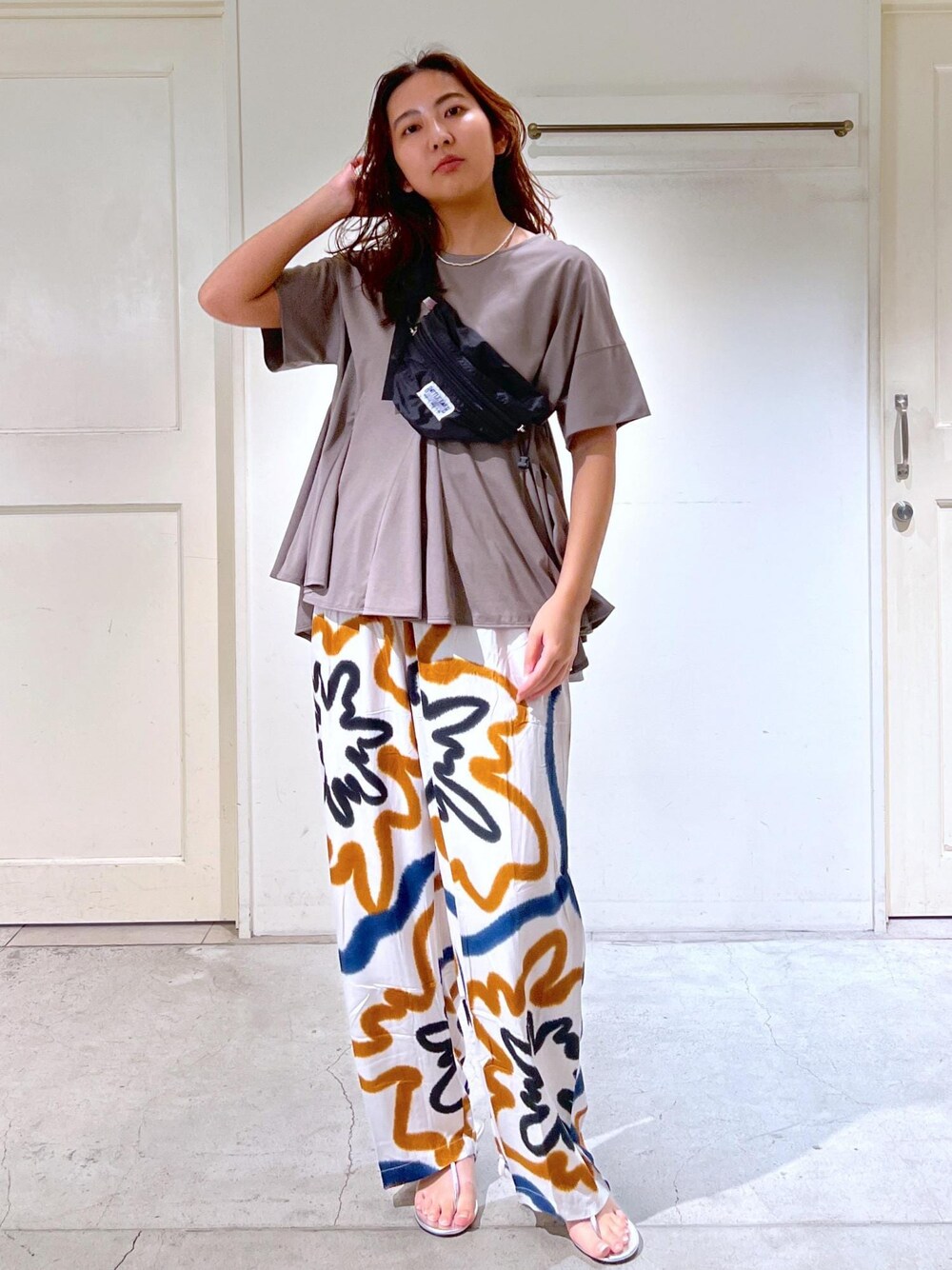 シルバー系のサンダル、グレー系のTシャツ/カットソーを着用したレディースの春コーディネートの1枚目の写真