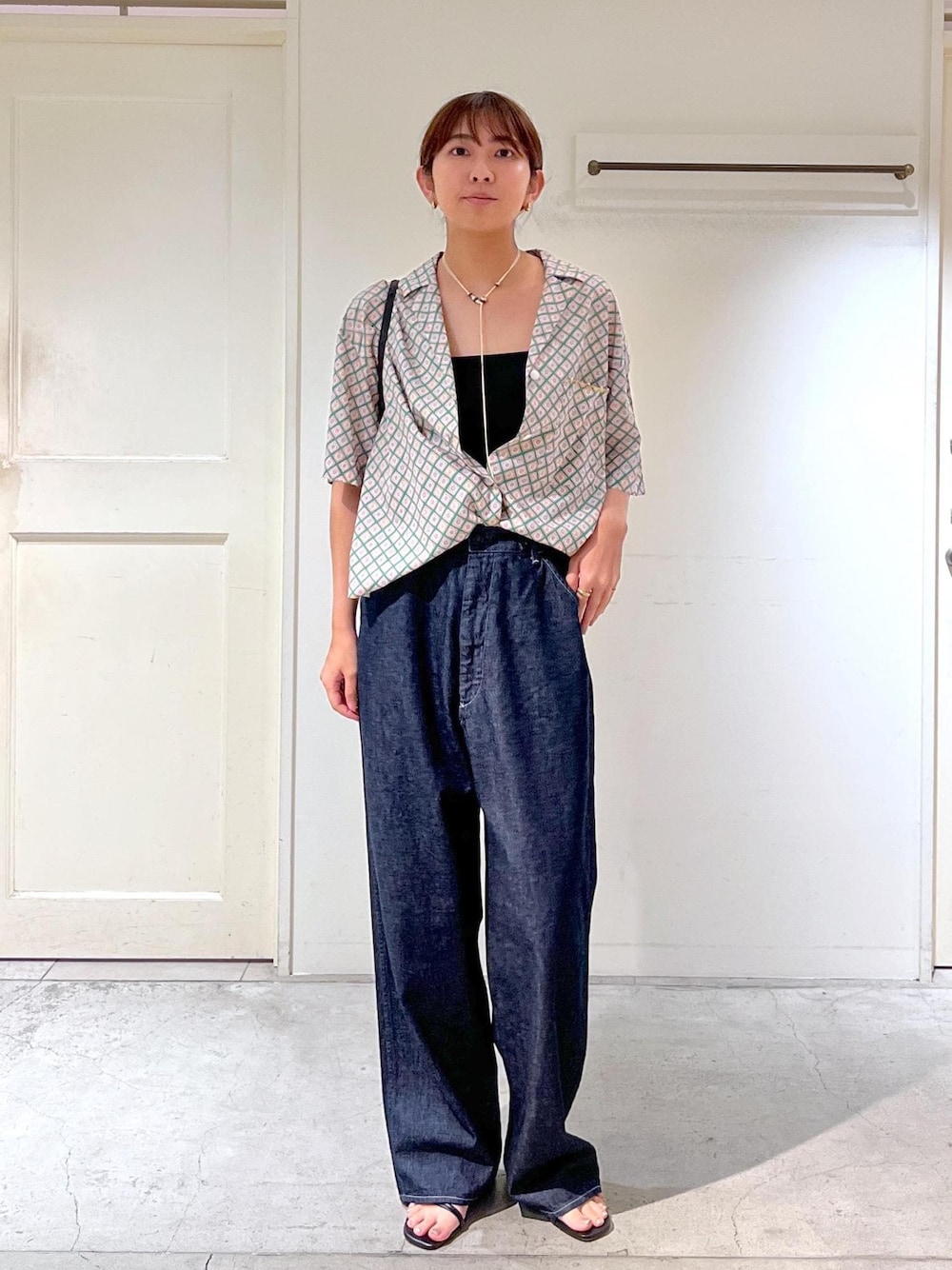 ブルー系のデニムパンツ、ブラック系のサンダル、グリーン系のシャツ/ブラウスを着用したレディースの夏コーディネートの1枚目の写真