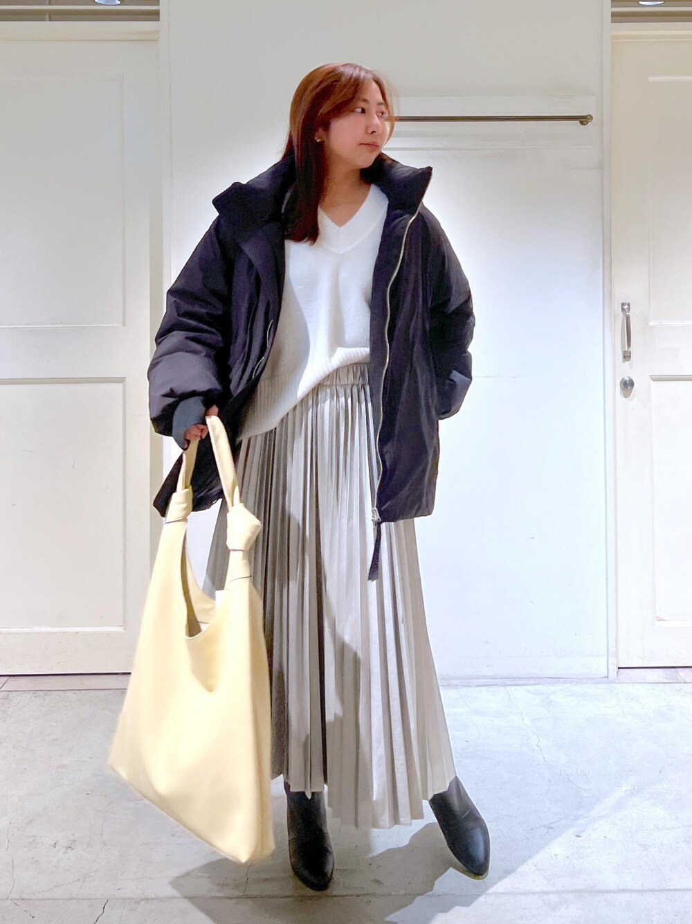 「ホワイト、ベージュ、トートバッグ、ニット、長袖、ダウン、ボリューム、Vネック、スカート、ロング、プリーツ、ブーツ、23AW Outer、サステナブル、骨格ストレート」｜「REMMEの【REMME（レメ）】ヒールショートブーツ（ブーツ、ブラック系）」を使った、EBATAさん（レディース・162cm）の秋コーディネートの1枚目の写真