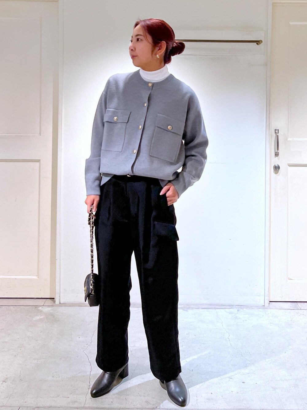 ブラック系のショルダーバッグ、ブラック系のブーツ、ホワイト系のTシャツ/カットソーを着用したレディースの冬コーディネートの1枚目の写真
