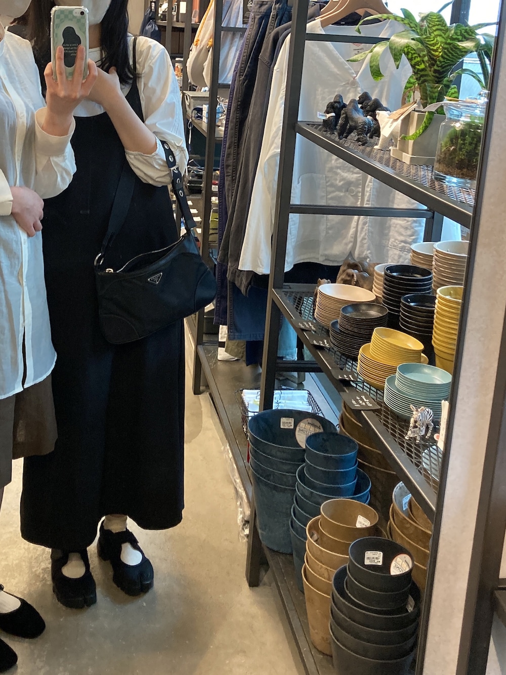 ブラック系のハンドバッグ、ブラック系のワンピース、ホワイト系のシャツ/ブラウスを着用したレディースの秋コーディネートの1枚目の写真