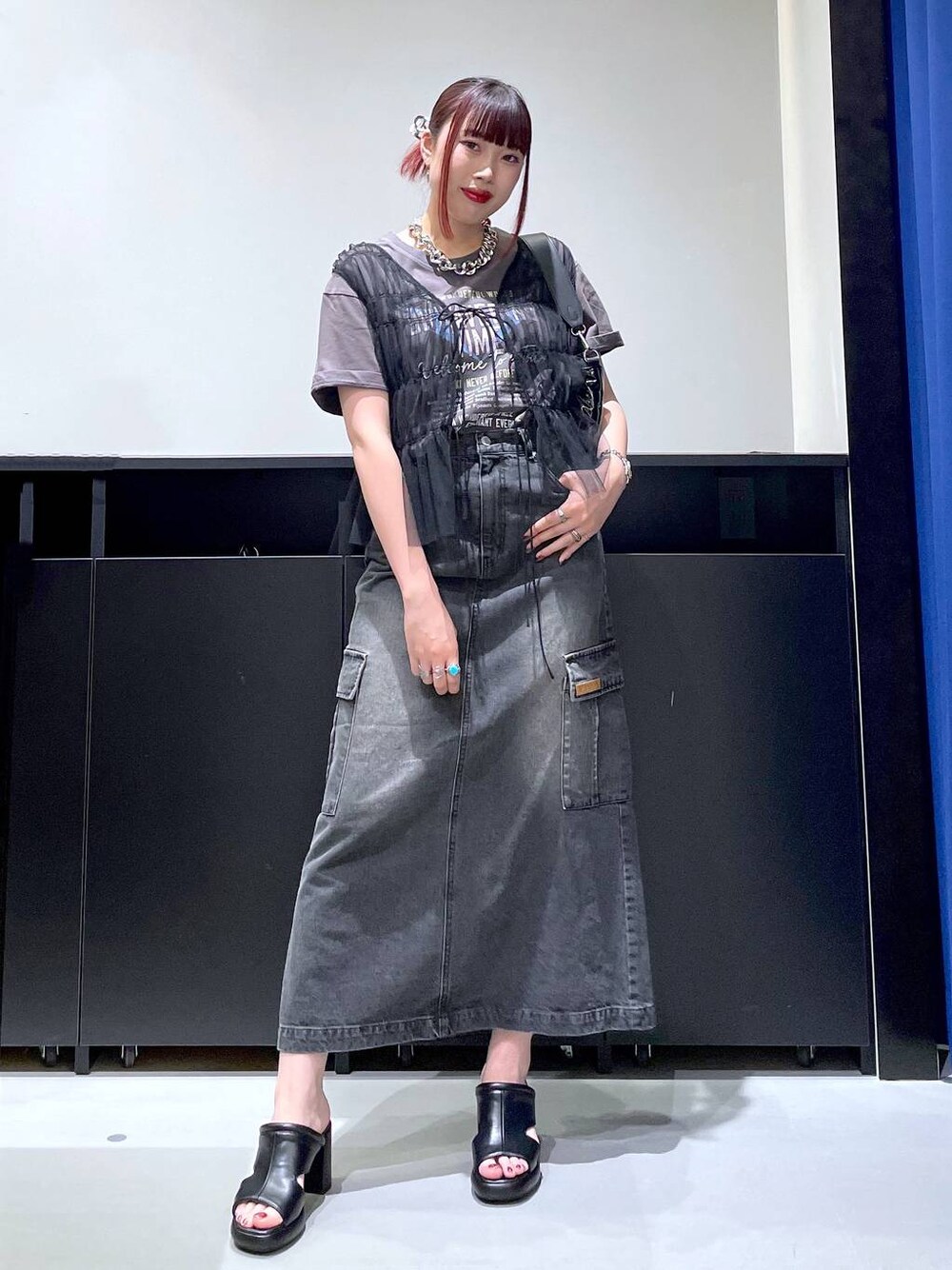 ブラック系のサンダル、ブラック系のデニムスカート、ブラック系のショルダーバッグを着用したレディースの夏コーディネートの1枚目の写真