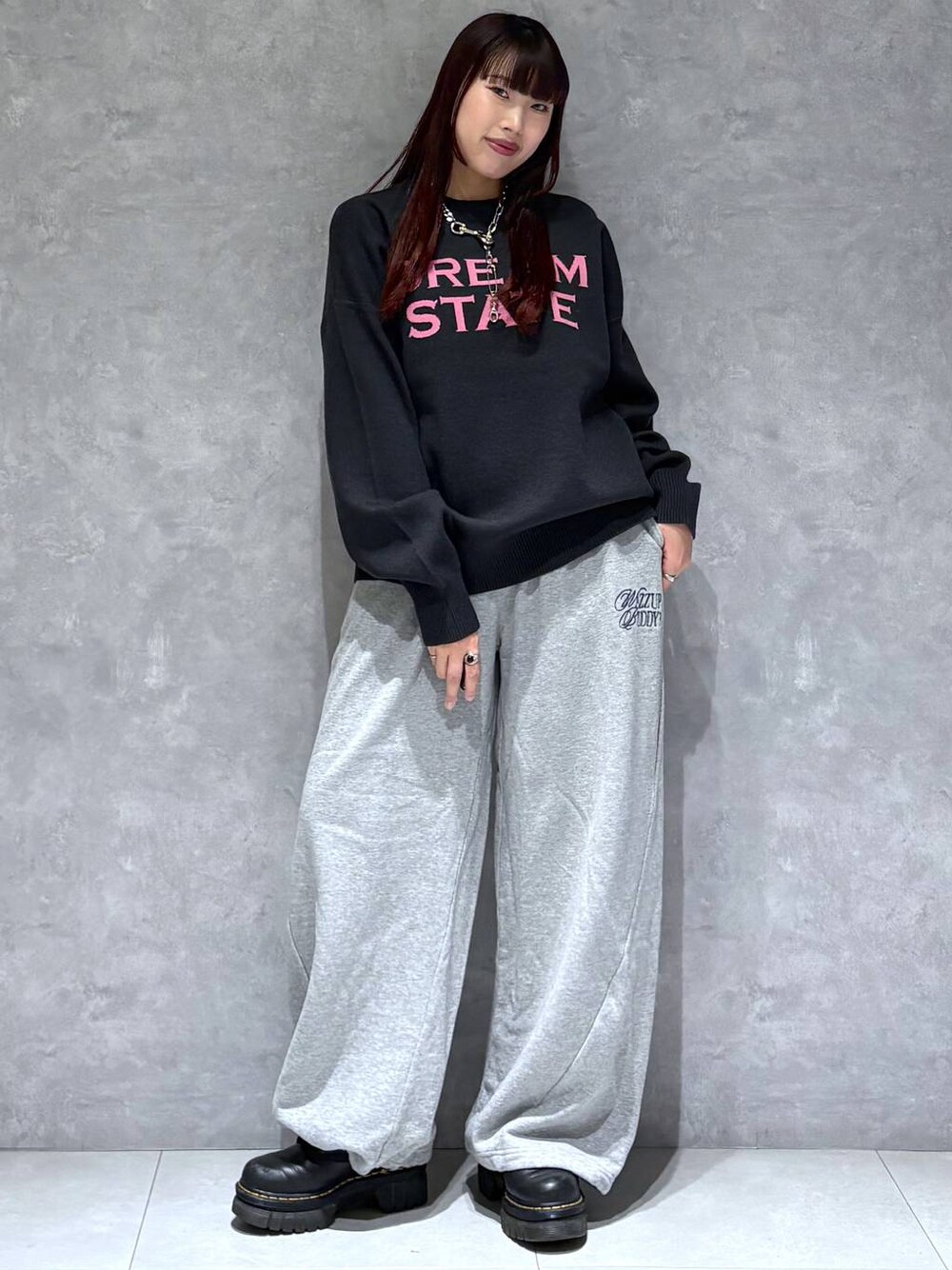 グレー系のスウェットパンツ、ブラック系のニット/セーターを着用したレディースの秋コーディネートの1枚目の写真
