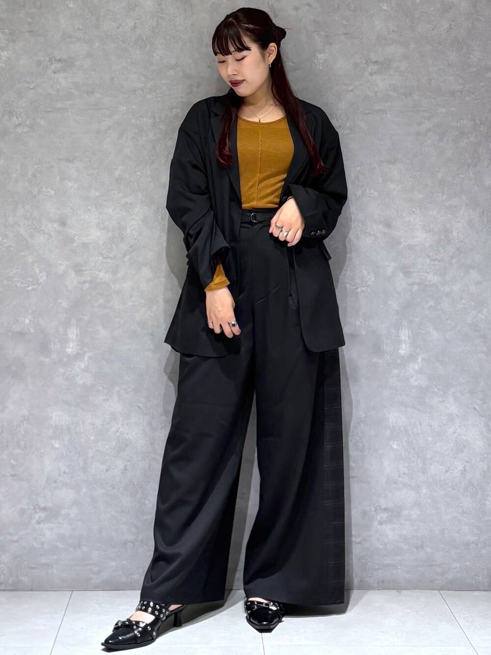 ブラック系のパンプス、ブラック系のテーラードジャケット、グレー系のスラックスを着用したレディースの秋コーディネートの1枚目の写真