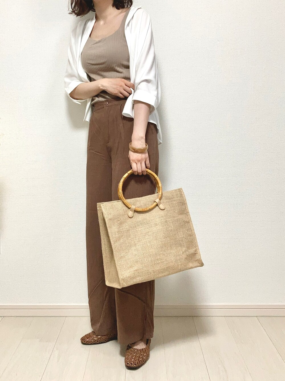 ホワイト系のシャツ/ブラウス、ベージュ系のハンドバッグ、ブラウン系のその他パンツを着用したレディースの夏コーディネートの1枚目の写真