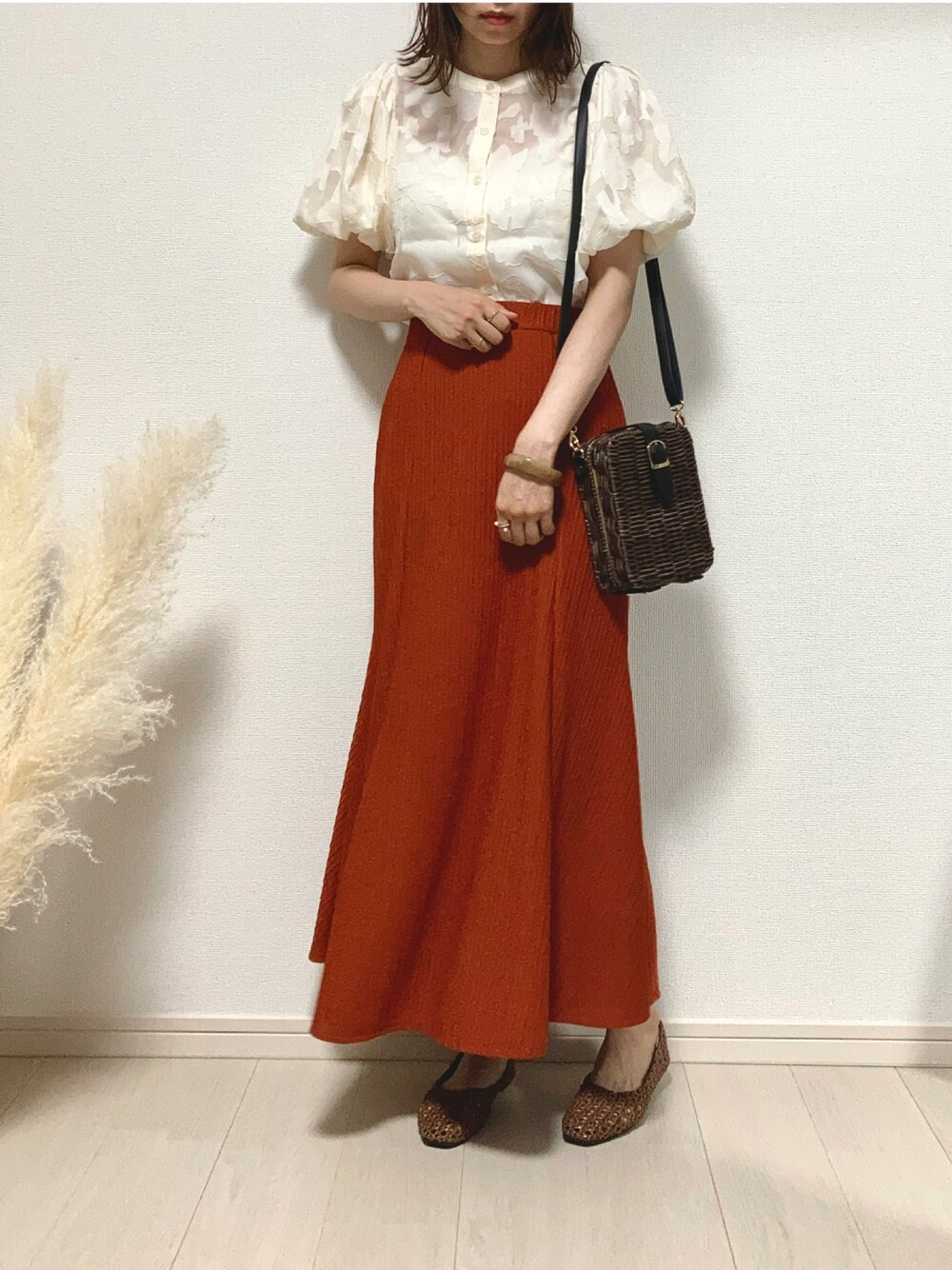 ホワイト系のシャツ/ブラウス、オレンジ系のスカート、ブラウン系のかごバッグを着用したレディースの夏コーディネートの1枚目の写真