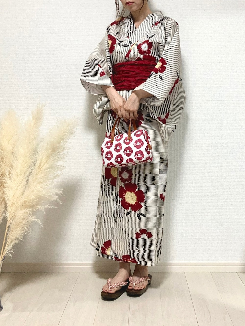 ピンク系のハンドバッグ、ブラック系の浴衣、レッド系の和装小物を着用したレディースの夏コーディネートの1枚目の写真