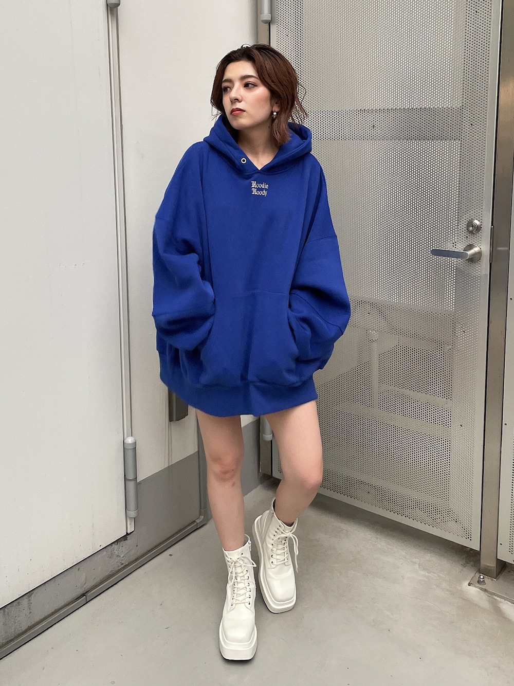 ブルー系のスウェット、ホワイト系のブーツを着用したレディースの秋コーディネートの1枚目の写真