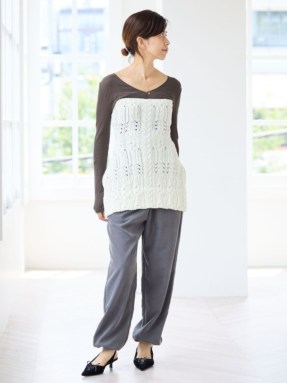 グレー系のその他パンツ、グレー系のTシャツ/カットソー、ホワイト系のニット/セーターを着用したレディースの秋コーディネートの1枚目の写真