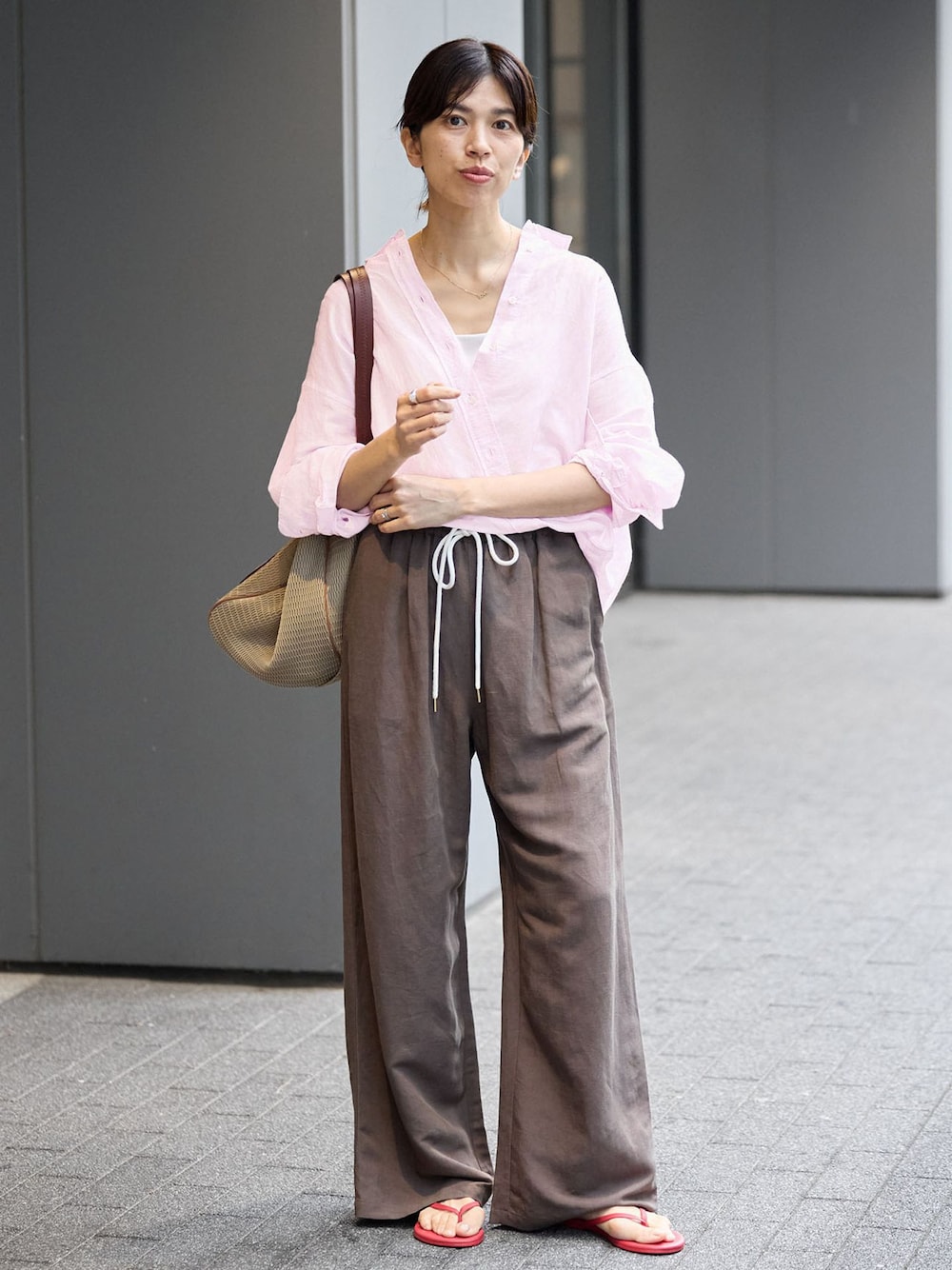 ブラウン系のその他パンツ、ピンク系のシャツ/ブラウス、レッド系のサンダルを着用したレディースの夏コーディネートの1枚目の写真
